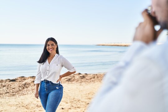 Man and woman couple smiling make photo using camera at seaside