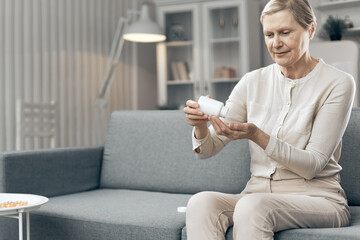 Age, medicine, healthcare and people concept. Senior woman taking pills at home.