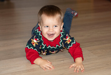 little boy lies on the floor and smiles