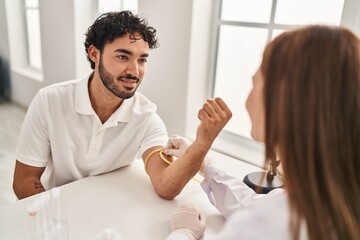 Fototapeta premium Man and woman wearing doctor uniform having blood analysis at clinic