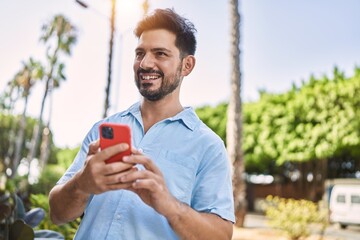 Young hispanic man smiling happy talking on the smartphone at the city.