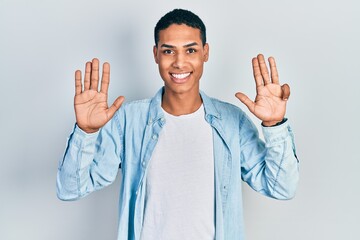 Young african american guy wearing casual clothes showing and pointing up with fingers number nine...