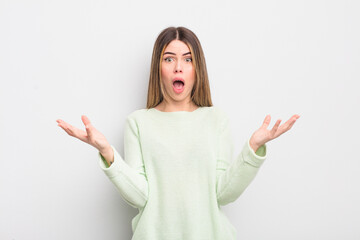 pretty young woman feeling extremely shocked and surprised, anxious and panicking, with a stressed...