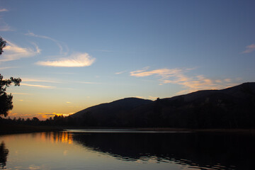 A Quiet Colorful Sunset over a Lake in Yucaipa, California, with the Sun Reflecting off of the Rippled Water Surface