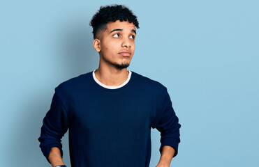 Young african american man wearing casual clothes smiling looking to the side and staring away thinking.