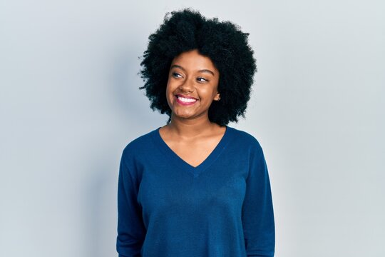Young african american woman wearing casual clothes looking to side, relax profile pose with natural face and confident smile.