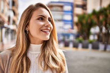 Fototapeta premium Young blonde woman smiling confident at street