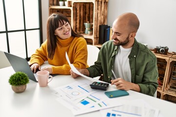 Young hispanic couple smiling happy using laptop sitting on the table at home.