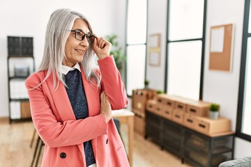 Fototapeta premium Middle age grey-haired woman business worker smiling confident standing at office