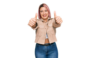 Obraz premium Hispanic woman with pink hair wearing casual clothes approving doing positive gesture with hand, thumbs up smiling and happy for success. winner gesture.