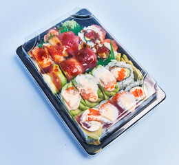 Delivery tray of uramaki sushi over blue background