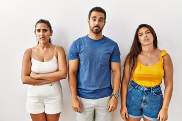 Group of young hispanic people standing over isolated background looking sleepy and tired, exhausted for fatigue and hangover, lazy eyes in the morning.