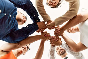 Obraz premium Group of business workers smiling happy standing with hands together at the office.