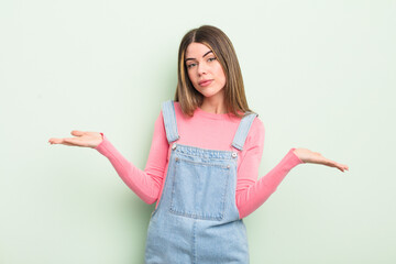 pretty young woman feeling puzzled and confused, unsure about the correct answer or decision,...