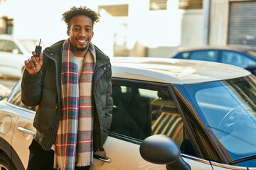Young african american man smiling happy holding key car at the city