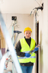 Caucasian repair man standing in apartment at stepladder with level in hands and looking at camera.