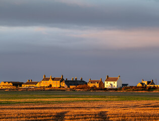 Fototapeta premium SPEY BAY, FOCHABERS, MORAY, SCOTLAND - 13 JANUARY 2022: This is the very small coastal hamlet getting the last of the sun at Spey Bay, Fochabers, Moray, Scotland on 13 January 2022.