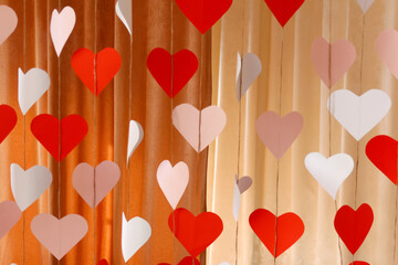Defocus banner. Valentines Day background with paper hearts. The red and white heart shapes for 14 February. Love symbol. Cupid's bow. Red backdrop. Pattern. Out of focus