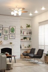 Stylish living room interior with comfortable chairs and decorative fireplace