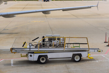 Airport ground service on conveyor belt to an airplane outdoors