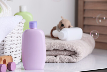 Obraz na płótnie Canvas Baby cosmetic products, toys and towel on white table