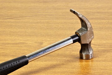Hammer is a construction locksmith tool for hammering fastening nails. Isolated on a wooden background.