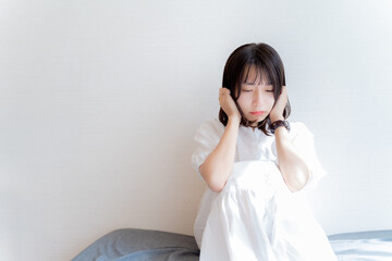 不安な表情で座る女性
