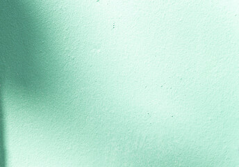 Sunlight shadow on green concrete cement wall texture background close-up abstract