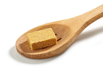 instant chicken broth cube in wooden spoon