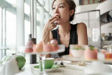 Obraz na płótnie Canvas asian woman enjoying afternoon tea in luxurious hotel