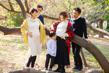 秋の公園　妊娠しているお母さんたちと家族のポートレート