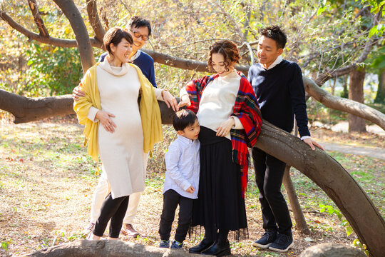 秋の公園　妊娠しているお母さんたちと家族のポートレート