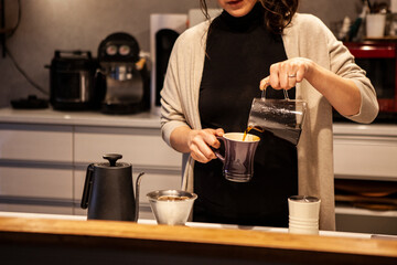 ドリップコーヒーを淹れる女性