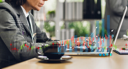 Portrait of success businesswoman using technology of laptop looking at progress of business financial investment data graph and chart business growth increase at office