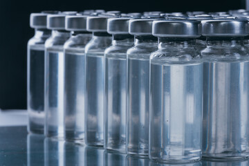 Glass medical ampoule vial for injection. Medicine is dry white drug penicillin powder or liquid with of aqueous solution in ampulla. Close up.