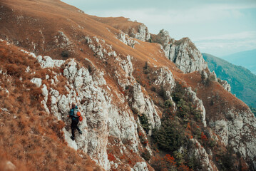 A male climber overcoming a difficult climbing route on the rock mountain cliff adrenaline extreme...