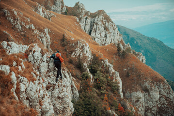 A male climber overcoming a difficult climbing route on the rock mountain cliff adrenaline extreme...