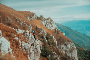 A male climber overcoming a difficult climbing route on the rock mountain cliff adrenaline extreme...