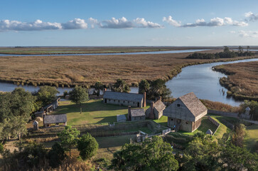 Aerial view of Fort King George historic site, oldest English fort on the Georgia coast from the 17th century with wooden palisade, gun ports for cannons blue cloudy sky near Darien Georgia USA - obrazy, fototapety, plakaty