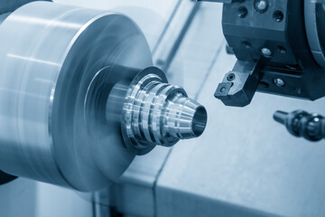 The  CNC lathe machine forming  cutting the metal cone shapes parts.