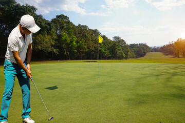 Obraz premium Background of evening golf course has sunlight shining down at golf course in Thailand. Nice scenery on a golf course at a late summer afternoon.