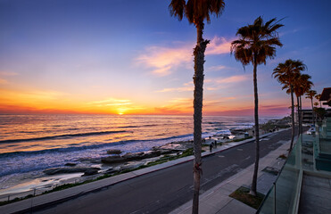 People stop to watch the sun dip below the horizon at Windansea Beach, San Diego - obrazy, fototapety, plakaty