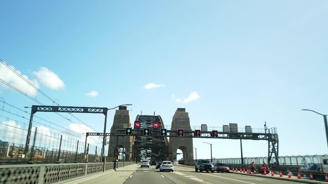 Driving through Cahill Expressway entering Sydney Harbour Bridge among the traffic in a multi lane highway with Sydney Skyline in the background to North Sydney