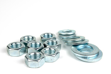 several nuts and washers made of silver metal close-up. isolated on white background