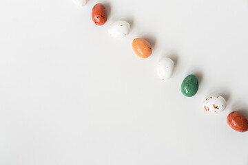 Easter minimal composition with multicolored eggs on the white background. Easter concept. Copy space, flat lay.