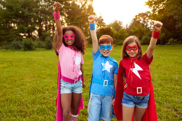 Group of diverse superhero kids standing with fists up