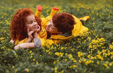 Content ginger siblings lying on flower meadow