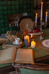 Blurry backgrounded table with chairs and vintage books and candles composition