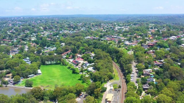 Aerial drone pullback view above Como Bridge on the Georges River in southern Sydney, looking toward Carina Bay and Como train station during summer on a sunny day 