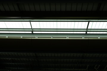 two ceilings and space between them with transparent awning and bright sunlight
